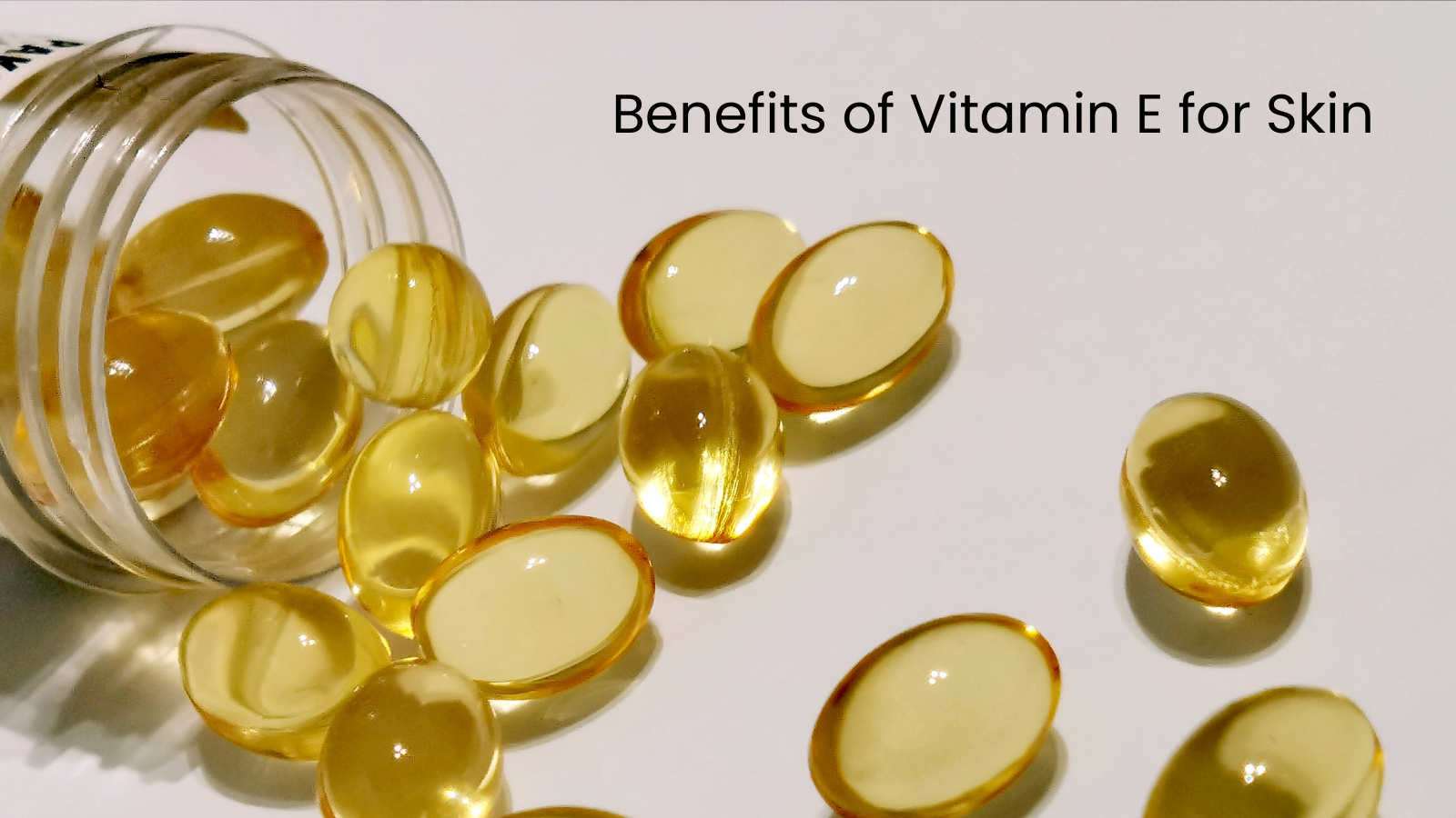 Shiny vitamin E capsules falling from a transparent jar, representing powerful antioxidant supplements that nourish skin from within.